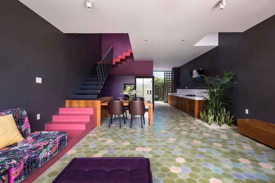  Phòng khách, nhà ăn, bếp liên thông nhau phía ngoài tầng trệt. Bếp hình chữ L giúp phân chia không gian tầng trệt một cách tối ưu. Bàn ăn và ghế sofa đặt liền với cầu thang tạo vẻ độc đáo, vui tươi.