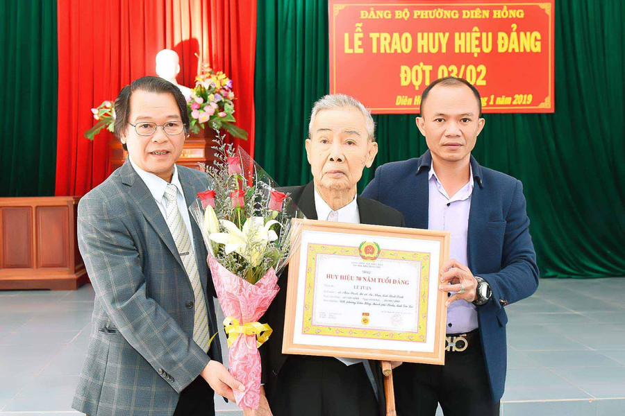 hó Bí thư Thành ủy-Chủ tịch UBND TP. Pleiku Trần Xuân Quang trao huy hiệu 70 năm tuổi đảng cho đảng viên Lê Toại. Ảnh: Đức Thụy