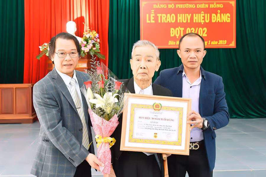 hó Bí thư Thành ủy-Chủ tịch UBND TP. Pleiku Trần Xuân Quang trao huy hiệu 70 năm tuổi đảng cho đảng viên Lê Toại. Ảnh: Đức Thụy