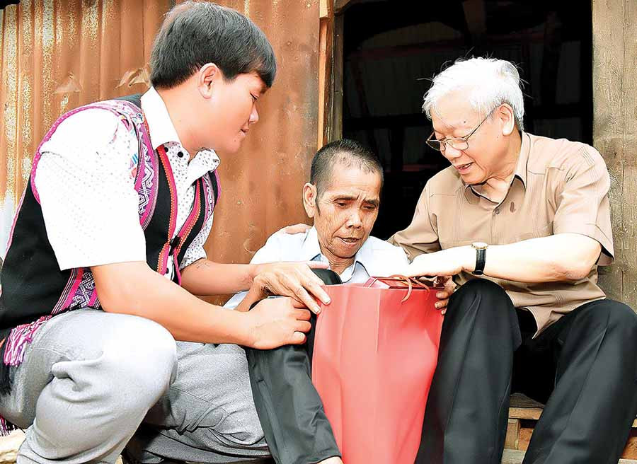 Tổng Bí thư Nguyễn Phú Trọng (bìa phải) tặng quà cho gia đình chính sách tại xã Ayun, huyện Chư Sê (tháng 4-2017). Ảnh: Đ.T
