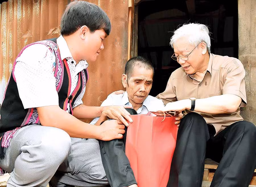 Tổng Bí thư Nguyễn Phú Trọng (bìa phải) tặng quà cho gia đình chính sách tại xã Ayun, huyện Chư Sê (tháng 4-2017). Ảnh: Đ.T