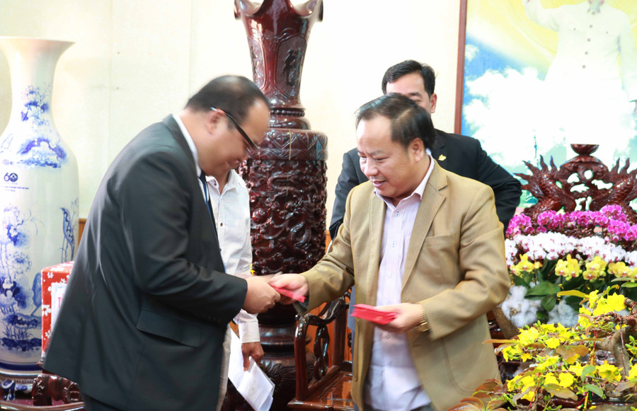 Phó Bí thư Tỉnh ủy Châu Ngọc Tuấn lì xì đầu năm mới cho thành viên đoàn cán bộ tỉnh bạn. Ảnh: Ngọc Sang