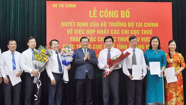 Bộ trưởng Tài chính Đinh Tiến Dũng chúc mừng các lãnh đạo chi cục thuế Quảng Ninh, khi tỉnh đi đầu cả nước hợp nhất 7 chi cục thuế. Ảnh: VGP