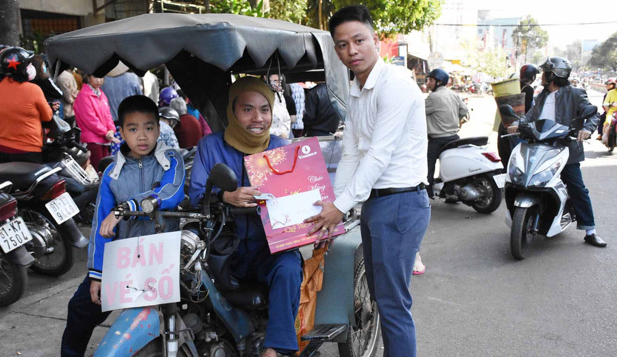 Đại diện Công ty cổ phần Vinpear thuộc Tập đoàn Vingroup tặng quà cho người khuyết tật. Ảnh: Hà Phương