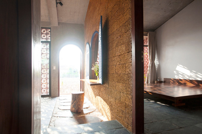 Bức tường phòng ngủ được làm từ đá tổ ong - một vật liệu tự nhiên mang từ Sơn Tây về. Dù đá tổ ong ít được sử dụng trong nội thất vì độ nhám và khó lắp chính xác, các thợ thủ công đá địa phương đã tinh chỉnh giúp tạo ra một bức tường với cửa sổ hình vòm có thể kết nối phòng ngủ với phòng khách. Bức tường phòng ngủ được làm từ đá tổ ong - một vật liệu tự nhiên mang từ Sơn Tây về. Dù đá tổ ong ít được sử dụng trong nội thất vì độ nhám và khó lắp chính xác, các thợ thủ công đá địa phương đã tinh chỉnh giúp tạo ra một bức tường với cửa sổ hình vòm có thể kết nối phòng ngủ với phòng khách.