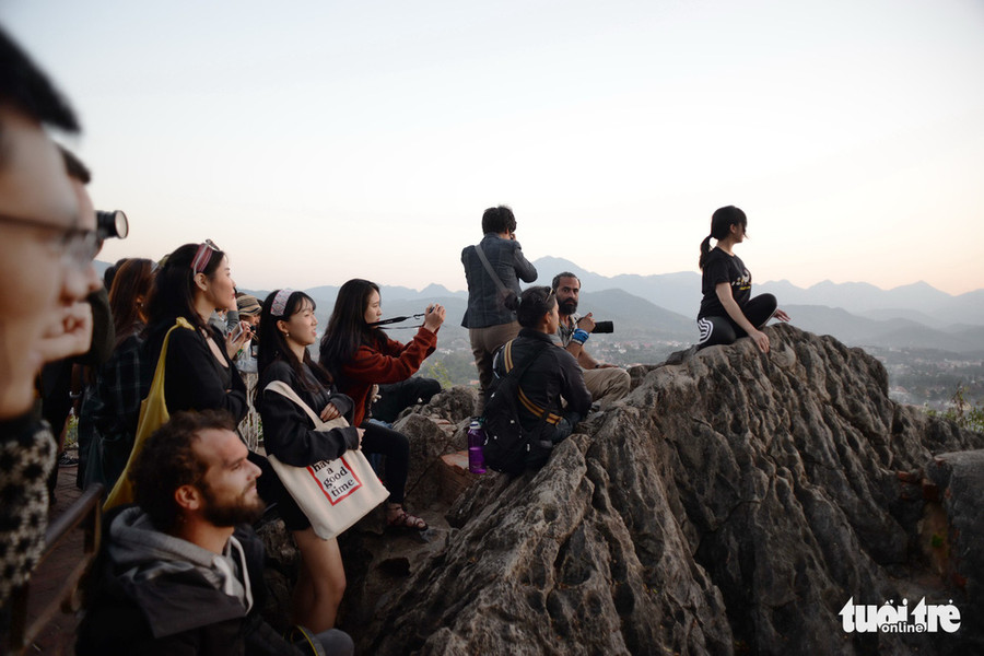  Nhóm bạn trẻ, các tay máy ngẩn ngơ khi mặt trời trốn sau dãy núi. Nhiệt độ từ 22 độ C xuống còn 19 độ C ngay khi mặt trời mất dạng - Ảnh: T.T.D.