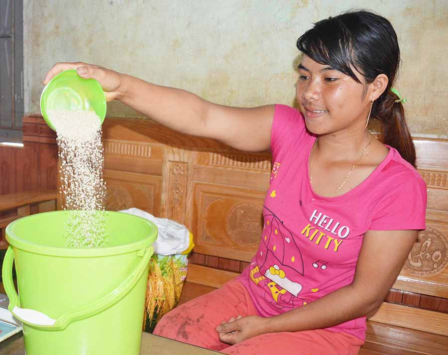 Hội viên Siu Chuyên xúc gạo mang đến nộp cho chi hội. Ảnh: P.D  Hội viên Siu Chuyên xúc gạo mang đến nộp cho chi hội. Ảnh: P.D