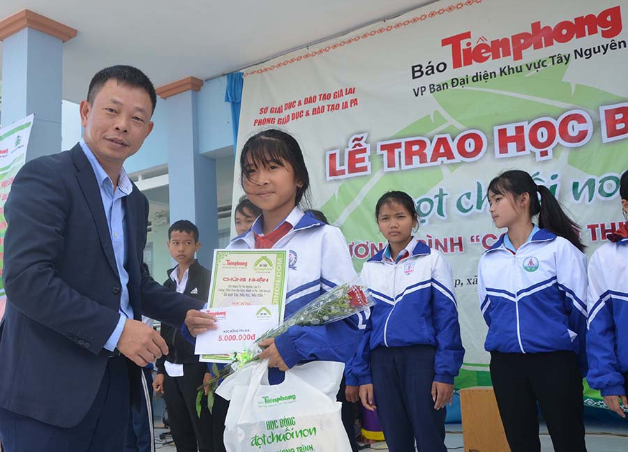 Nhà báo Phùng Công Xưởng-Phó Tổng biên tập Báo Tiền Phong trao học bổng “Tài năng trẻ” của Trung ương đoàn cho 4 học sinh xuất sắc. Ảnh: Đức Phương