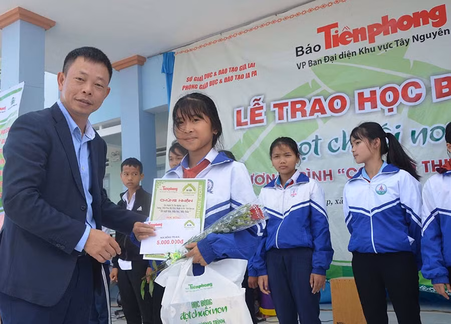 Nhà báo Phùng Công Xưởng-Phó Tổng biên tập Báo Tiền Phong trao học bổng “Tài năng trẻ” của Trung ương đoàn cho 4 học sinh xuất sắc. Ảnh: Đức Phương