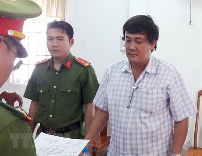  Lực lượng chức năng đọc lệnh bắt giam giam bị can Đỗ Minh Thống. (Ảnh: Thế Anh/TTXVN)