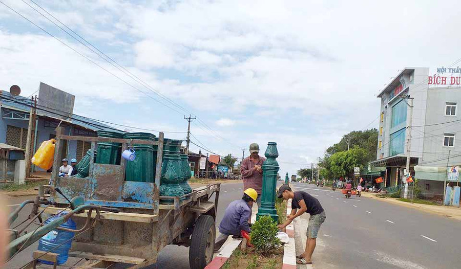 Công nhân Ban Quản lý Công trình đô thị và Vệ sinh Môi trường huyện Chư Pưh đã xây dựng và lắp các trụ bông cảnh cho giải phân cách. Ảnh: Nhật Hào