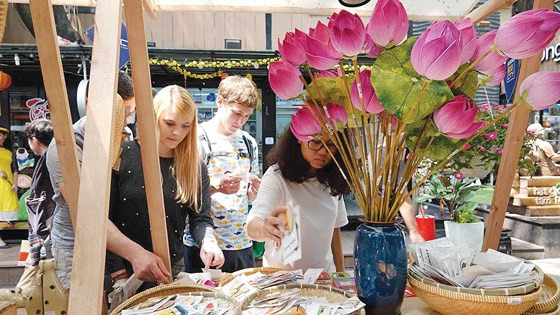 Khách nước ngoài thích thú với không khí Tết Việt ở Đường sách TPHCM. Ảnh: DŨNG PHƯƠNG 