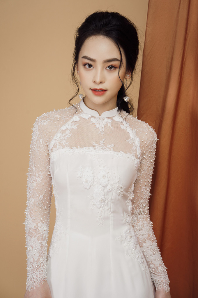 Các chi tiết cườm, hạt được đính kết dọc cánh tay giúp áo có độ bắt sáng tự nhiên, khiến cô dâu trở thành tâm điểm của lễ ăn hỏi, đám cưới. Các chi tiết cườm, hạt được đính kết dọc cánh tay giúp áo có độ bắt sáng tự nhiên, khiến cô dâu trở thành tâm điểm của lễ ăn hỏi, đám cưới.