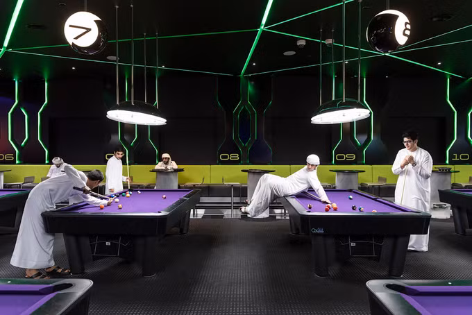 Các chàng trai người Dubai chơi billiard tại Hub Zero, công viên trò chơi, nằm trong trung tâm mua sắm City Walk. Theo số liệu từ chính phủ, ở Dubai có đến 70% nam giới, đứng hàng đầu thế giới về tỷ lệ chênh lệch giới tính. Ở những khu dân cư với đa số là người lao động nghèo như quận Sonapur, gần như không có phụ nữ. 92% những người sống ở Dubai đến từ khắp nơi trên thế giới. Người nhập cư đã góp công lớn trong việc xây dựng thành phố.
