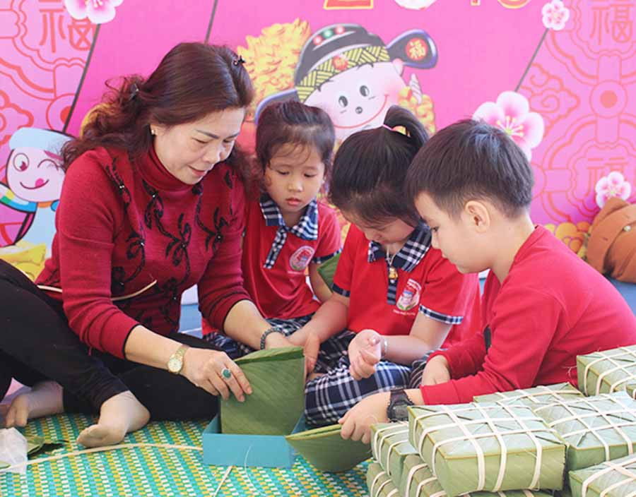 Học sinh Trường Mầm non Hoa Hồng (TP. Pleiku) tìm hiểu cách gói bánh chưng. Ảnh: N.G Học sinh Trường Mầm non Hoa Hồng (TP. Pleiku) tìm hiểu cách gói bánh chưng. Ảnh: N.G