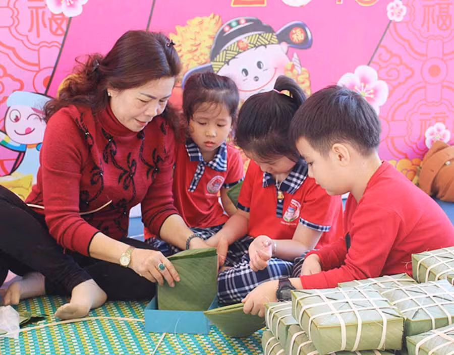 Học sinh Trường Mầm non Hoa Hồng (TP. Pleiku) tìm hiểu cách gói bánh chưng. Ảnh: N.G Học sinh Trường Mầm non Hoa Hồng (TP. Pleiku) tìm hiểu cách gói bánh chưng. Ảnh: N.G