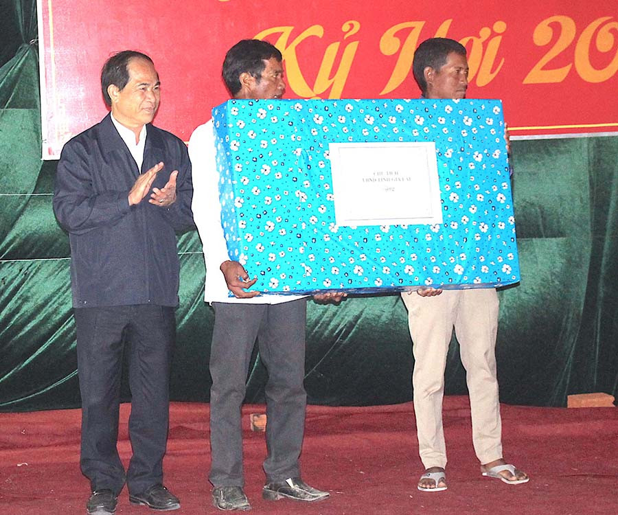 Chủ tịch UBND tỉnh Võ Ngọc Thành trao quà cho tập thể làng Hek. Ảnh: Tấn Thi
