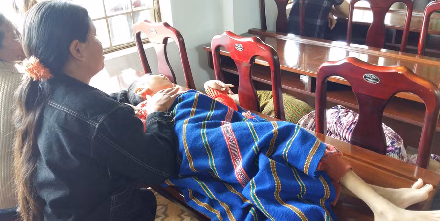 Bà Rơ Lan Thừa đưa con bị bệnh bẩm sinh đến nhận quà Tết. Ảnh: Hà Phương