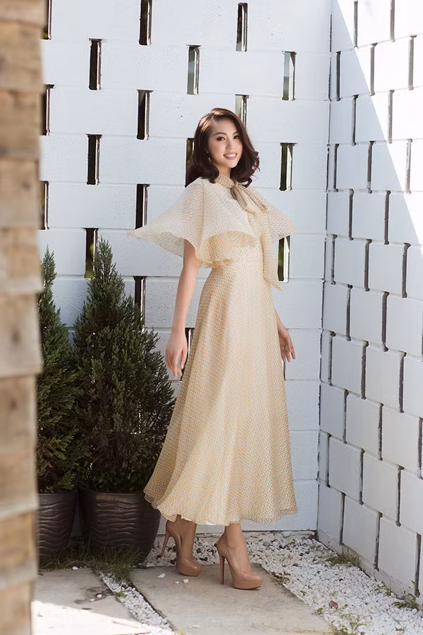 Váy lụa mềm được trang trí phần cầu vai rộng, xếp layer và tạo khối xoè mang tới điểm nhấn bắt mắt cho tổng thể.