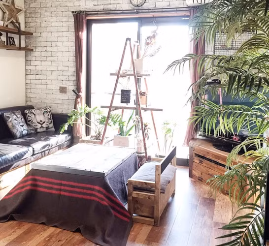 Thùng gỗ cũ, thảm len và mặt bàn kính tạo thành chiếc bàn nước độc đáo mà không kém phần thu hút.