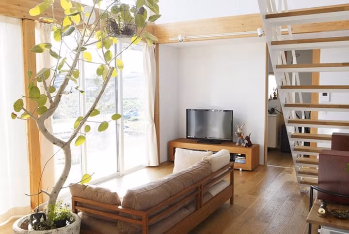 Phòng khách đóng khung trong một bộ sofa gỗ đơn giản cùng chiếc tivi là nơi sinh hoạt chung của các thành viên trong gia đình.