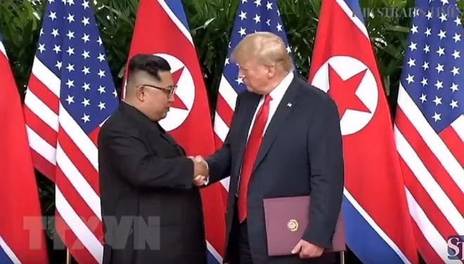 Tổng thống Mỹ Donald Trump (phải) và nhà lãnh đạo Triều Tiên Kim Jong-un tại cuộc gặp ở Singapore. (Nguồn: Yonhap/TTXVN) Tổng thống Mỹ Donald Trump (phải) và nhà lãnh đạo Triều Tiên Kim Jong-un tại cuộc gặp ở Singapore. (Nguồn: Yonhap/TTXVN)
