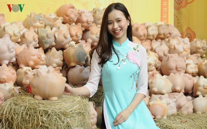 Các cô gái chụp ảnh với heo đất trên phố Ông Đồ.