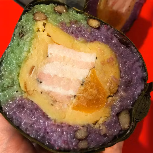 Người miền Trung ăn bánh tét kèm dưa món. Một số biến tấu đẹp mắt của hương vị truyền thống còn có bánh tét lá cẩm trứng muối, bánh tét ba màu, bánh tét ngọt… Bánh được gói thành những đòn trụ dài nên khi cắt từng khoanh nhìn đẹp mắt. Ảnh: Aizphong, anvatocsen.