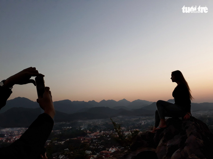  Cô Malgorzata Urbanowicz (Ba Lan) được bạn chụp ảnh trong ánh hoàng hôn trên đỉnh Phousi. Cô cho biết Việt Nam là điểm đến trong hành trình kế tiếp - Ảnh: T.T.D.