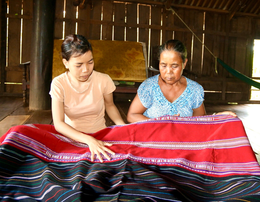Bà H'Wik Niê (buôn Bling) chỉ dạy con gái cách dệt hoa văn, họa tiết trên chăn.