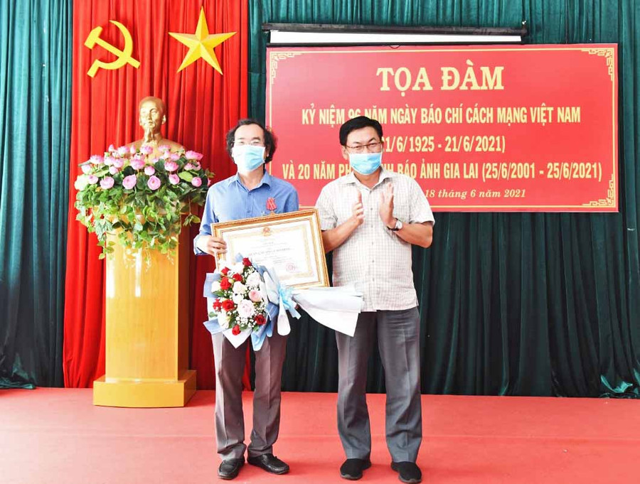 Thừa ủy nhiệm của Chủ tịch nước, Tổng Biên tập Báo Gia Lai Huỳnh Kiên trao Huân chương lao động hạng 3 cho Phó Tổng Biên tập Báo Gia Lai Khuất Đình Viện. Ảnh: Đức Thụy