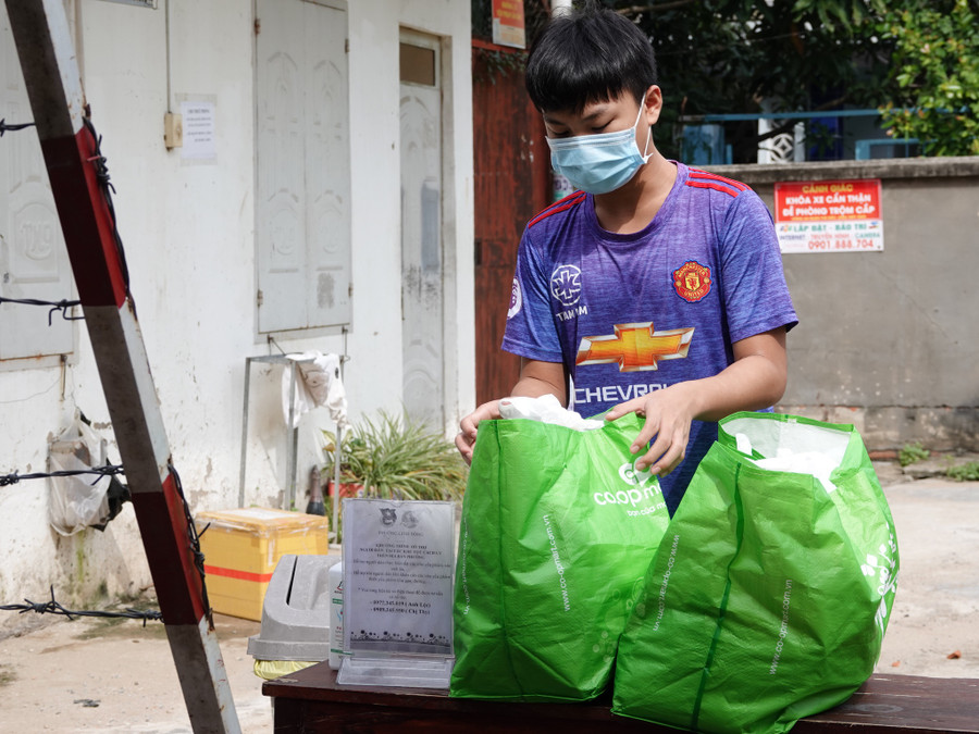 Người dân ở khu vực phong tỏa trong hẻm 74 đường số 36, P.Linh Đông, TP.Thủ Đức nhận quà từ siêu thị nghĩa tình - ẢNH: SỸ ĐÔNG