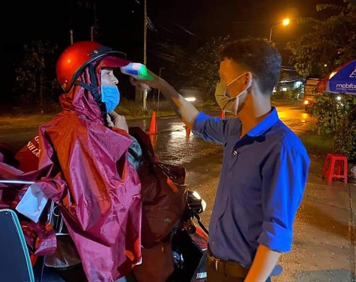 Kiểm tra thân nhiệt tại chốt kiểm soát dịch Covid-19 trước khi vào địa phận Lâm Đồng. ẢNH: LÂM VIÊN