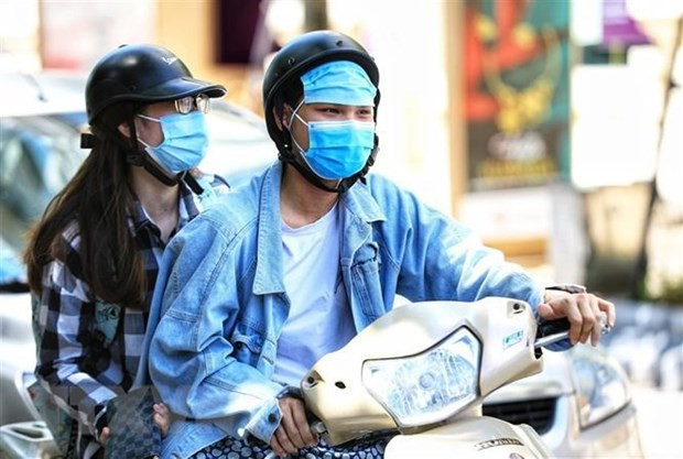 Đôi bạn trẻ dùng khẩu trang đeo lên trán để tránh cái nắng gay gắt. (Ảnh: Thành Đạt/TTXVN) Đôi bạn trẻ dùng khẩu trang đeo lên trán để tránh cái nắng gay gắt. (Ảnh: Thành Đạt/TTXVN)