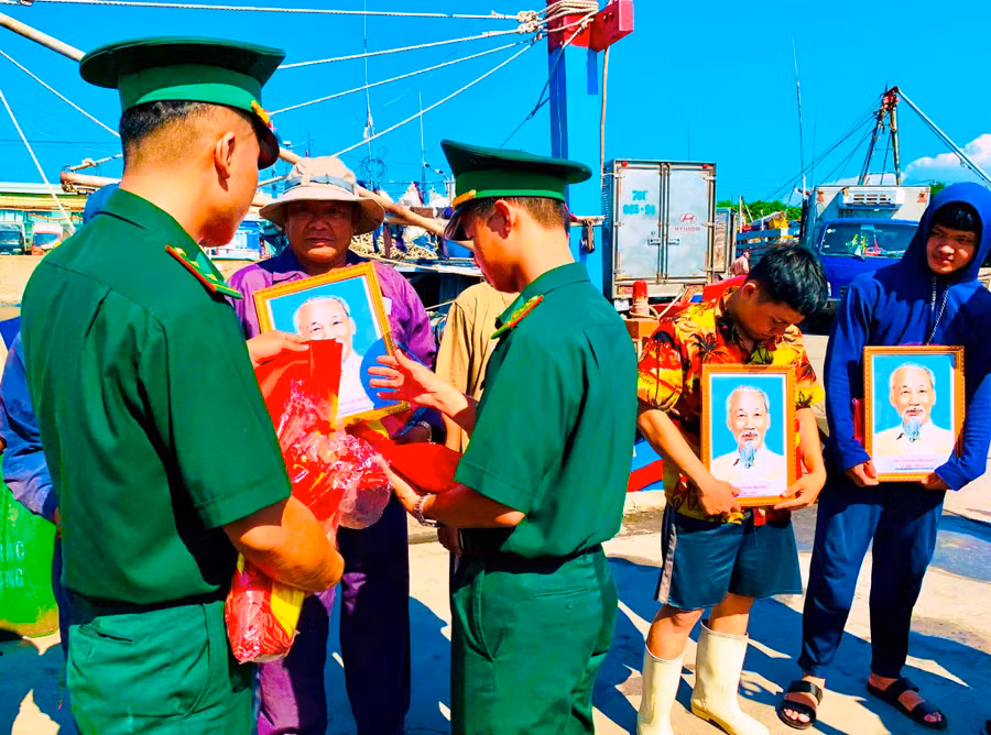 Cán bộ Đồn biên phòng Sơn Trà (Đà Nẵng) đồng hành cùng ngư dân qua các chương trình tặng ảnh Bác Hồ, cờ Tổ quốc, phao cứu sinh… - ẢNH: S.X