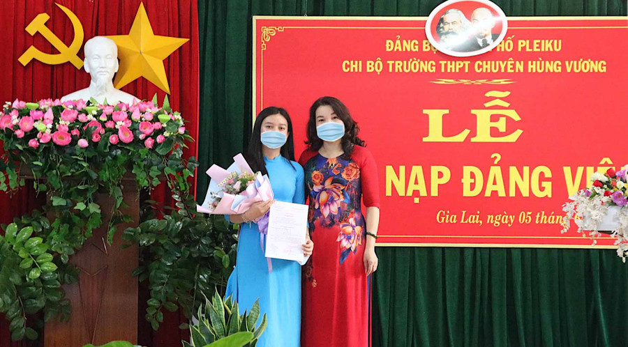 Cô Lê Thị Thu-Bí thư Chi bộ, Hiệu trưởng Trường THPT chuyên Hùng Vương trao quyết định kết nạp đảng viên cho em Trần Hoài Vi (lớp 12B). Ảnh: Mộc Trà