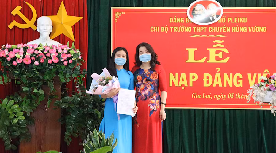 Cô Lê Thị Thu-Bí thư Chi bộ, Hiệu trưởng Trường THPT chuyên Hùng Vương trao quyết định kết nạp đảng viên cho em Trần Hoài Vi (lớp 12B). Ảnh: Mộc Trà