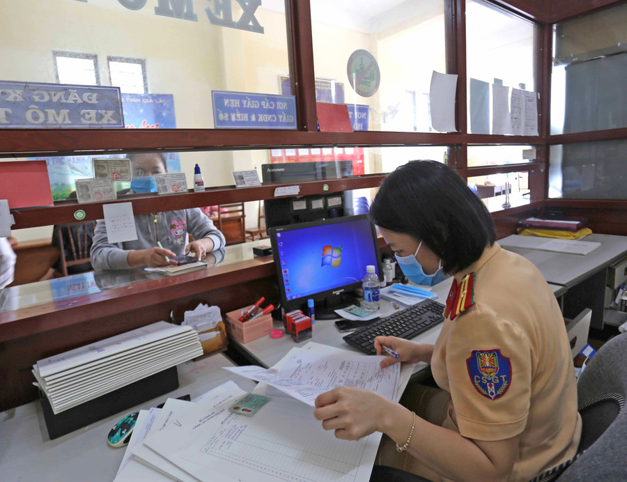 Lực lượng Cảnh sát Giao thông làm thủ tục sang tên phương tiện cho người dân. Ảnh: Lê Văn Ngọc Lực lượng Cảnh sát Giao thông làm thủ tục sang tên phương tiện cho người dân. Ảnh: Lê Văn Ngọc