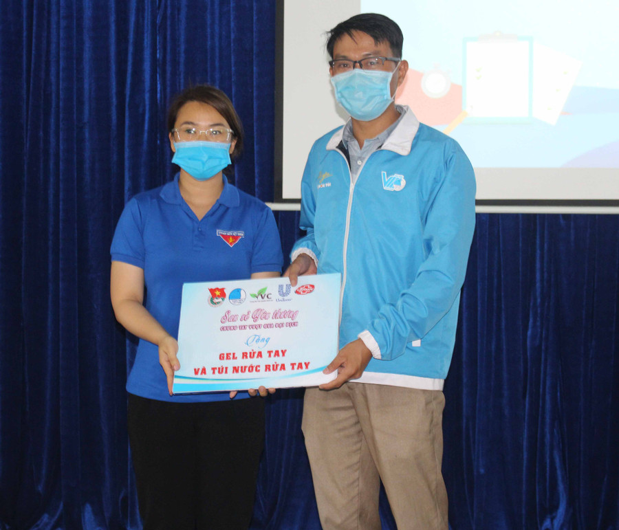 Anh Nguyễn Chí Cẩn (bìa phải)-Phó Chủ tịch Hội Liên hiệp Thanh niên Việt Nam tỉnh tặng nước rửa tay cho đại diện Ban Chỉ đạo chương trình “Tư vấn-Tiếp sức mùa thi” năm 2021. Ảnh Phan Lài.