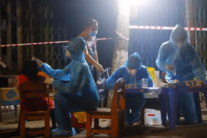 Lực lượng chức năng tỉnh Bình Dương lấy mẫu xét nghiệm cho 40.000 người dân tại phường Bình Chuẩn đêm 24 rạng sáng 25-6