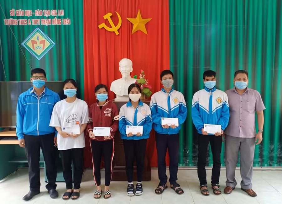  Anh Trịnh Công Duy(bìa trái)-quyền Bí thư Huyện Đoàn Chư Păh tặng quà cho các học sinh khó khăn Trường THCS-THPT Phạm Hồng Thái. Ảnh: Phan Lài