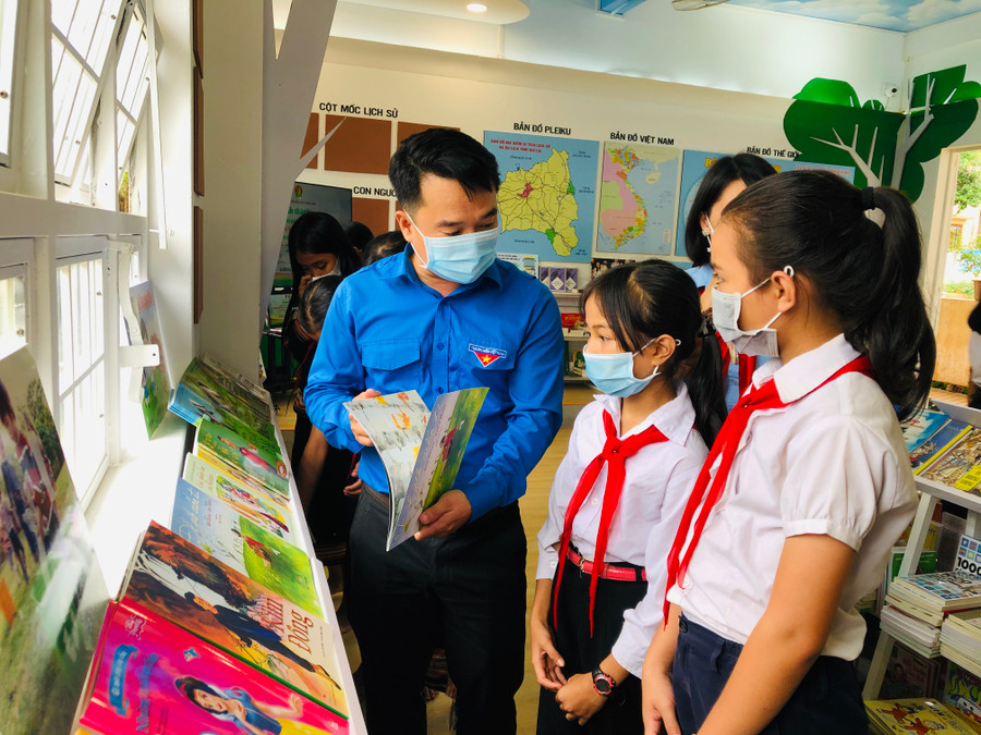 Anh Đỗ Duy Nam-Phó Bí thư Tỉnh Đoàn hướng dẫn các em học sinh Trường Tiểu học Anh Hùng Núp đọc sách tại thư viện. Ảnh: Thủy Bình
