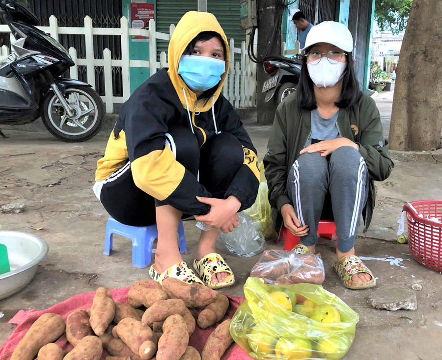 Em Nguyễn Thị Bích Vân (bìa phải) và Nguyễn Thị Bảo Nhi bán củ quả ở một góc vỉa hè chợ Yên Thế. Ảnh: Hà Tây