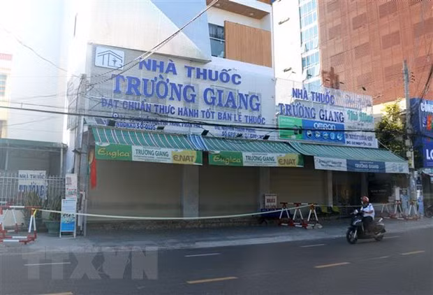 Phong tỏa tạm thời nhà thuốc Trường Giang (nơi trường hợp nghi nhiễm có đến mua thuốc) tại thành phố Phan Thiết. (Ảnh: Nguyễn Thanh/TTXVN)
