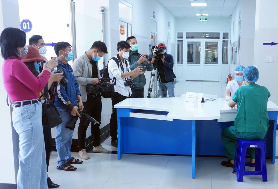 Phóng viên tác nghiệp tại điểm tiêm vắc xin phòng Covid-19 ở Bệnh viện Đa khoa tỉnh. Ảnh: Hùng Hoa Lư
