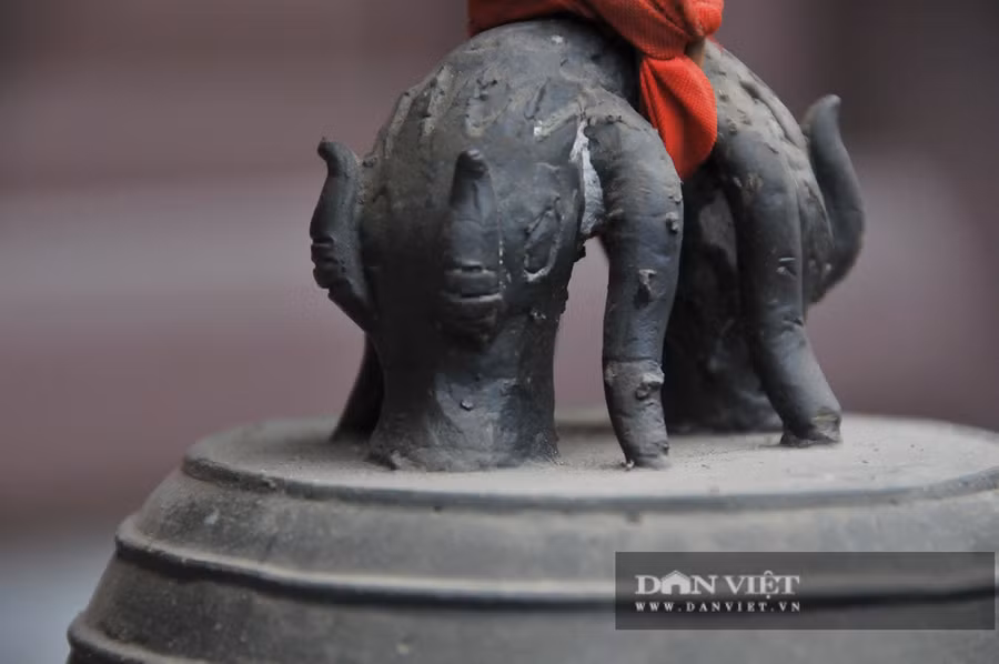 Quai chuông đúc nổi đôi thú (giống như Ly Thủ) đấu lưng vào nhau, uốn cong tạo thành núm treo chuông. Thú có đầu to, mắt lồi, hai sừng thẳng, bờm ôm sát đầu, thân có vảy, hai chân và miệng ngậm tỳ xuống đỉnh chuông tạo thế vững chắc cho quai chuông. Chỏm quai tạo hình núm tròn dẹt nhô lên nhưng không phải là hồ lô như trên các quai chuông sau này. Đỉnh chuông bằng, vai xuôi, thân hình trụ, miệng loe có gờ, thành chuông dày.