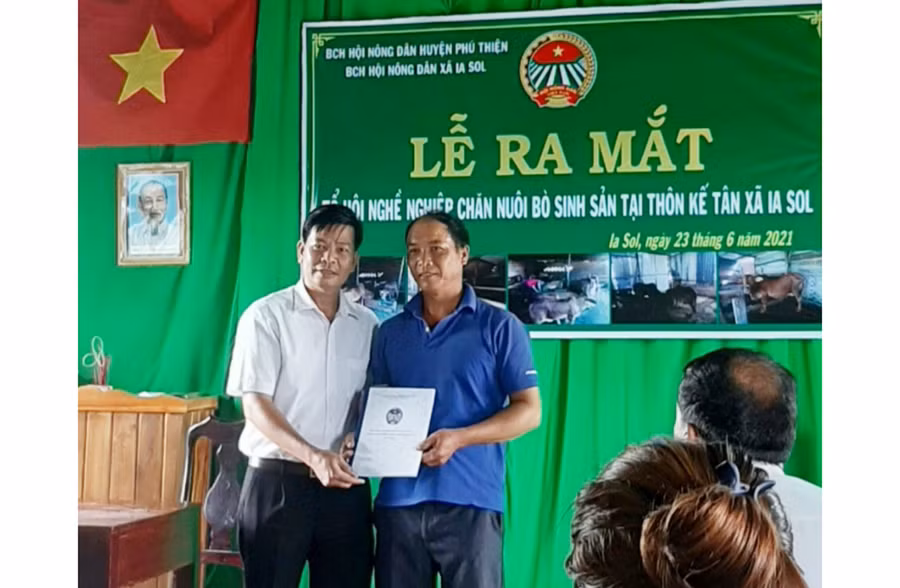  Chủ tịch Hội Nông dân xã trao quyết định thành lập Tổ hội chăn nuôi bò sinh sản thôn Kế Tân. Ảnh: Vũ Chi