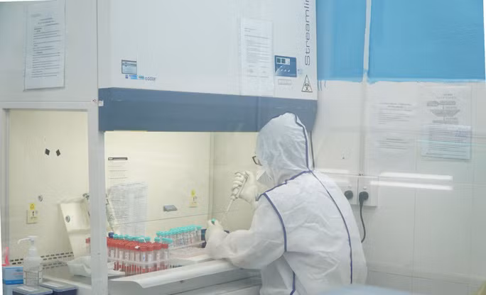 Kỹ thuật viên xử lý mẫu ban đầu trong quy trình xét nghiệm Covid-19 bằng phương pháp RT-PCR