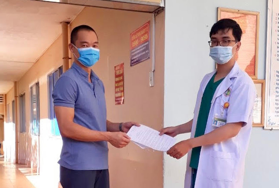 Cán bộ y tế trao giấy ra viện cho bệnh nhân 6601. Ảnh: Như Nguyện Cán bộ y tế trao giấy ra viện cho bệnh nhân 6601. Ảnh: Như Nguyện