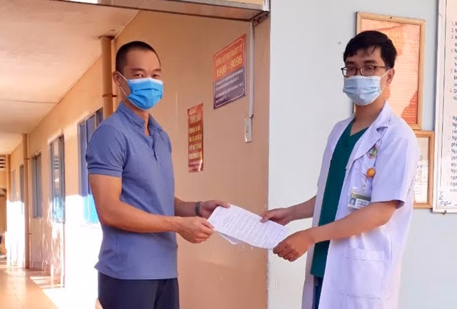  Cán bộ y tế trao giấy ra viện cho bệnh nhân 6601. Ảnh: Như Nguyện